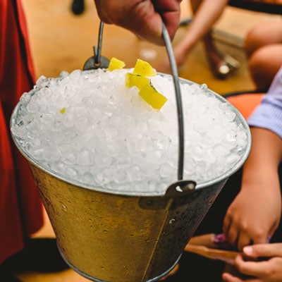 Cleaning ice bucket with lemon peels at a social gathering, highlighting professional event cleaning services by C&W Commercial.